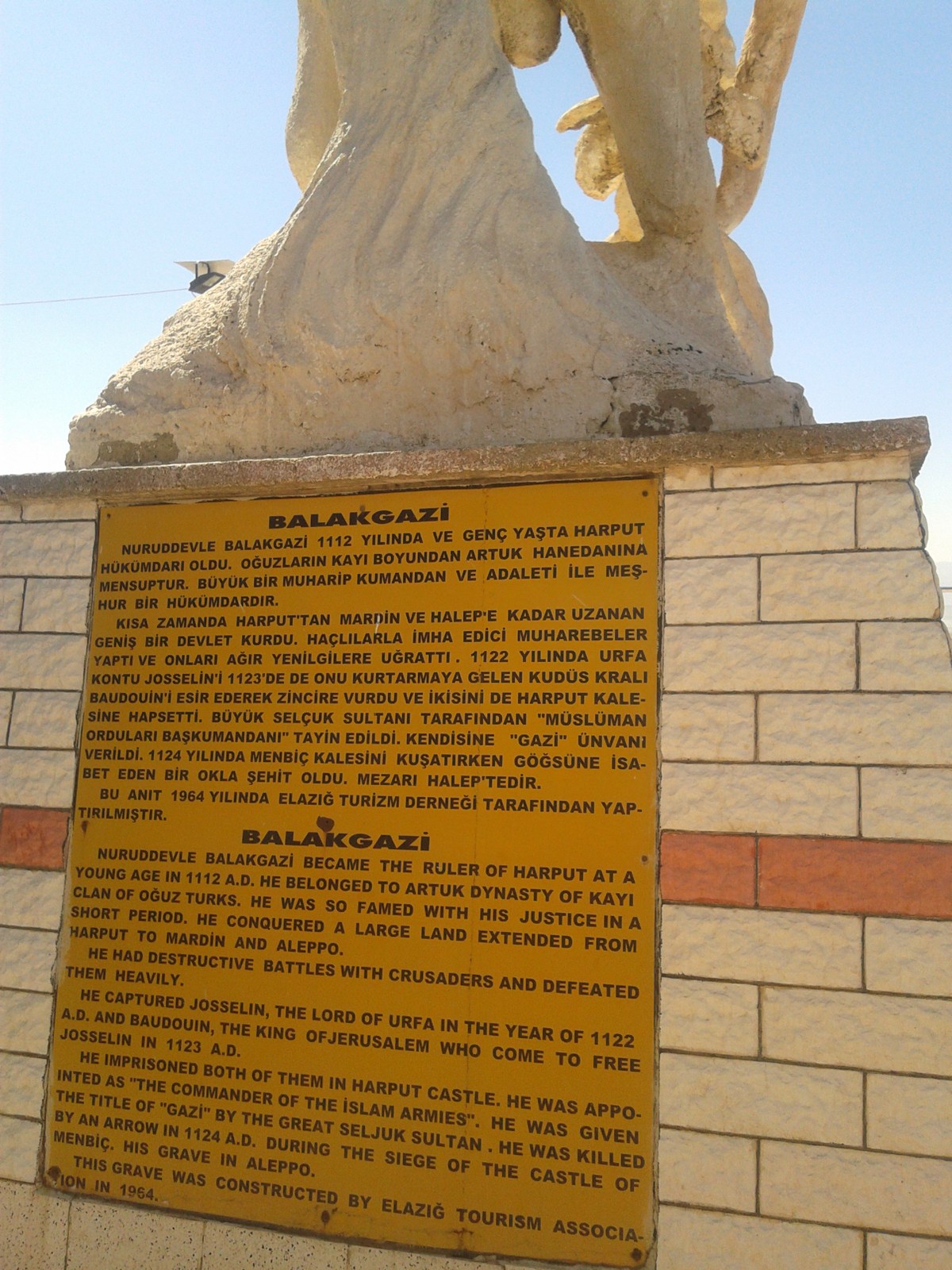 Turkish and English inscriptions on the stone pedestal of the Balak Gazi monument in Harput.